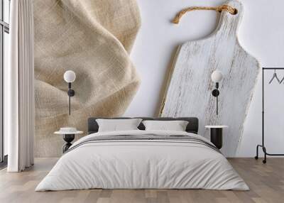 A white painted wooden cutting board and a coarse beige linen napkin on a white table Wall mural