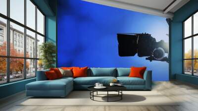 Professional video camera on abstract blue lights background with copy space, movie, television or broadcasting banner Wall mural