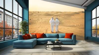 Arabic men in the desert of Dubai wearing traditional emirates clothing Wall mural