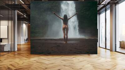 Beautiful girl having fun at the waterfalls in Bali. Concept about wanderlust traveling and wilderness culture Wall mural