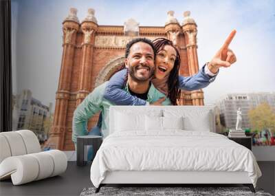 Beautiful happy hispanic latino couple of lovers dating outdoors - Tourists in Barcelona having fun during summer vacation and visiting Arc de Triumf historic landmark Wall mural