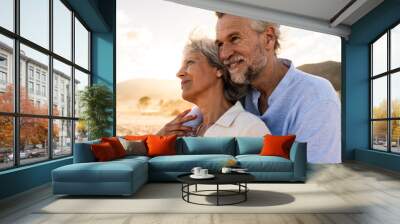 Beautiful happy senior couple dating at the seaside during summertime - Mature married couple in love bonding outdoors at the beach, concepts about elderly lifestyle, relationship and quality of life Wall mural