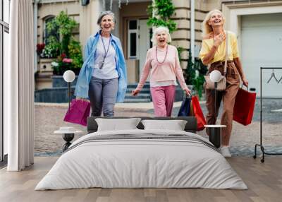 Beautiful happy senior women shopping in the city centre - Mature female adult friends with colorful stylish clothes meeting and spending time together Wall mural