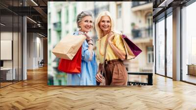 Beautiful happy senior women shopping in the city centre - Mature female adult friends with colorful stylish clothes meeting and spending time together Wall mural