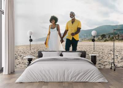 Beautiful mature black couple of lovers dating at the seaside - Married african middle-aged couple bonding and having fun outdoors, concepts about relationship, lifestyle and quality of life Wall mural