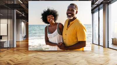 Beautiful mature senior black couple of lovers dating at the seaside - Married african middle-aged couple bonding and having fun outdoors, concepts about relationship, lifestyle and quality of life Wall mural