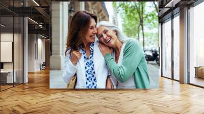 Beautiful senior women meeting outdoors in the city - Two mature female adults friends bonding and having fun while shopping outdoors Wall mural