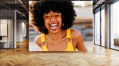 Beautiful young black woman outdoors in the city - Afro american cheerful female adult portrait Wall mural