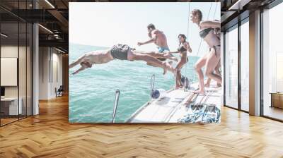 Friends jumping in the water from the boat Wall mural