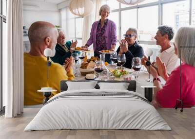 Group of happy senior friends bonding at home for dinner party - Cheerful and youthful old mature multiethnic people having fun Wall mural