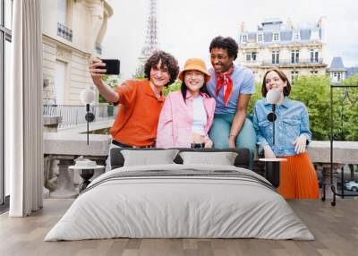 Group of young happy friends visiting Paris and Eiffel Tower - Multiethnic teens bonding outdoors and having fun sightseeing the city Wall mural