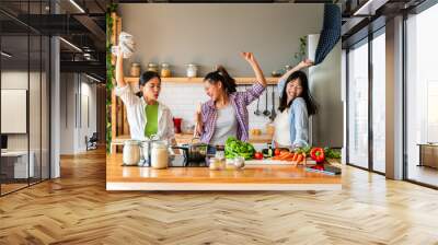 Happy beautiful chinese women friends bonding at home and cooking delicious meal together- Playful asian female adults meeting and having fun at home, concepts about domestic life and friendship Wall mural