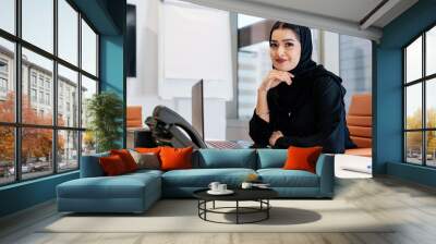 Middle-eastern businesswoman wearing traditional arab abaya working in the office in Dubai Wall mural