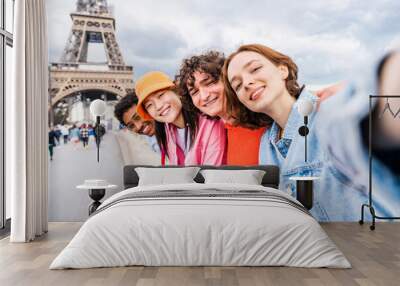 Multiethnic group of young happy teens friends bonding and having fun while visiting Eiffel Tower area in Paris, France Wall mural