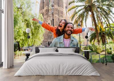 Multiracial beautiful happy couple of lovers dating at Sagrada Familia, Barcelona - Multiethnic tourists travelling in Europe and visiting a city in Spain, concepts about tourism and people lifestyle Wall mural