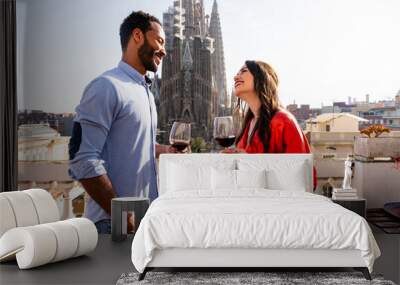 Multiracial beautiful happy couple of lovers dating on rooftop balcony at Sagrada Familia, Barcelona - Multiethnic people having romantic aperitif on a terrace with city view , concept about tourism Wall mural