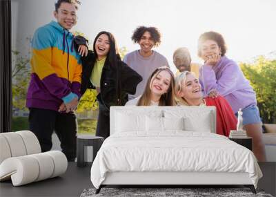 Multiracial group of young friends bonding outdoors, concepts of teenage, lifestyle, diversity and social inclusiveness Wall mural