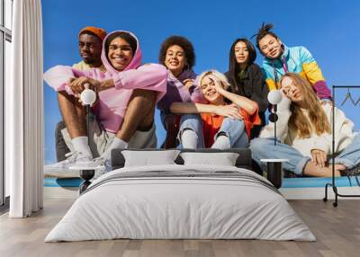 Multiracial group of young friends bonding outdoors Wall mural