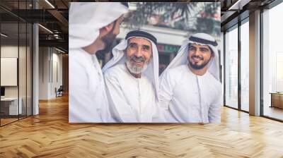 Three business men walking in Dubai wearing traditional emirati clothes Wall mural