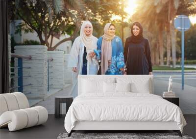 Three women friends going out in Dubai. Girls wearing the united arab emirates traditional abaya Wall mural