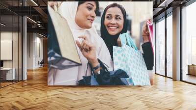 Two arabian girls spending time together outdoor making activities. Young women making shopping in Dubai Wall mural