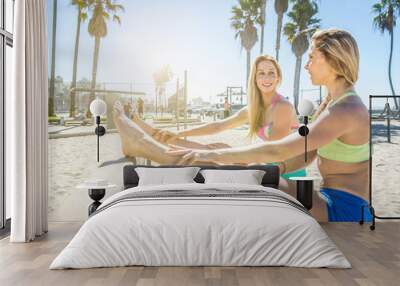 Two sisters making stretching on the beach in Los angeles Wall mural