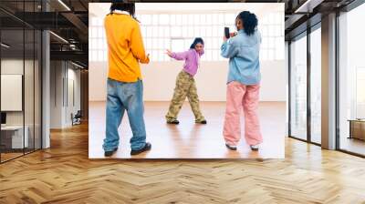 YYoung group of multiethnic hip-hop dancers wearing colorful urban streetwear dancing - Stylish multiracial rap crew portrait in indoors dancing studio Wall mural