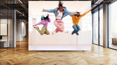 YYoung group of multiethnic hip-hop dancers wearing colorful urban streetwear dancing - Stylish multiracial rap crew portrait in indoors dancing studio Wall mural