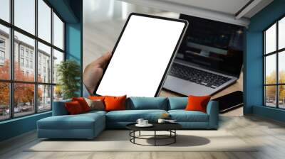 A businessman holds a mockup. iPad digital tablet with blank screen Mockup replaces your design mockup in the office. Wall mural