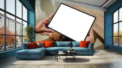 A businessman holds a mockup. iPad digital tablet with blank screen Mockup replaces your design mockup in the office. Wall mural