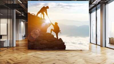 Climbing team are on the climb to the cliff,hiking and team work concept.    Mountaineer climbing a steep cliff. Wall mural