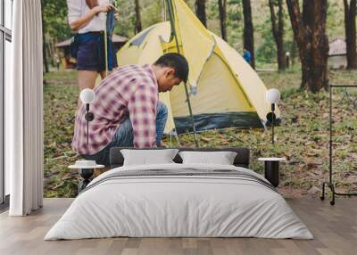 Hiking man sitting to set up a tent in national park Travel lifestyle success concept adventure Wall mural