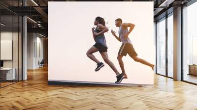 young couple runner running on running road in city park Wall mural