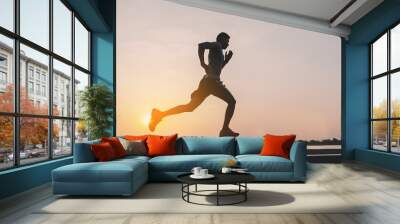 young man runner running on running road in city park Wall mural