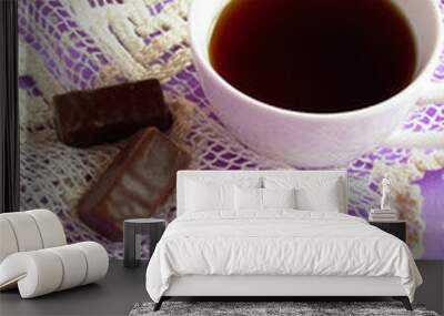 A Cup of black coffee, 2 chocolate candies on a white and purple background, good morning  Wall mural