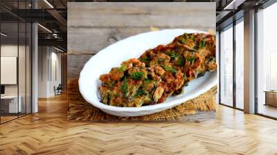 Fried eggplant cutlets with garlic and dill on a white plate and a vintage wooden background. Delicious summer vegetarian recipe. Closeup Wall mural