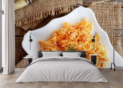 Vegetable risotto on a plate, fork, cutting board on old wooden background. Rice cooked with tomatoes, carrots, garlic and spices. Easy vegetarian rice recipe Wall mural