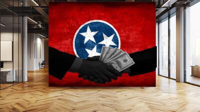 Two men/politicians in suits holding money/US Dollars and shaking hands with the national flag on the background - Tennessee - United States Wall mural