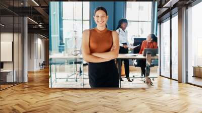 Doing business with confidence. Cropped portrait of an attractive young businesswoman standing with her arms folded in an office doorway. Wall mural