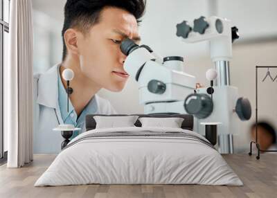 Medical, science and microscope with an asian man doctor working in a lab for research or innovation. Healthcare, investigation and experiment with a male scientist in a laboratory for analysis Wall mural