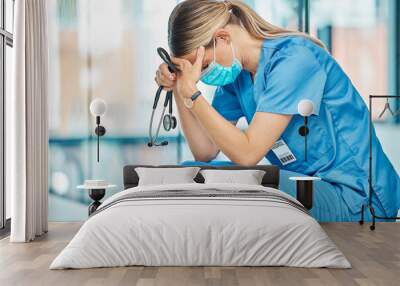 Stress, tired nurse and woman in hospital with depression, burnout or anxiety for mistake. Sad, surgery fail and medical worker with grief, fatigue or headache in healthcare clinic with stethoscope Wall mural