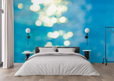 Bokeh light effects over a rippled, blue water background Wall mural