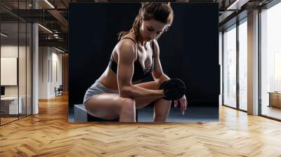 athletic young woman doing a fitness workout with dumbbells on black studio background Wall mural