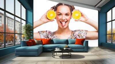 Beauty Model Girl with Juicy Oranges. Beautiful Joyful teen girl with freckles, funny red hairstyle and yellow makeup . Professional make up. Orange Slices. Isolated on a white background Wall mural