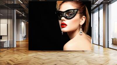 Beauty model woman wearing venetian masquerade carnival mask at party isolated on black background. Christmas and New Year celebration. Glamour lady with perfect make up and hairstyle Wall mural