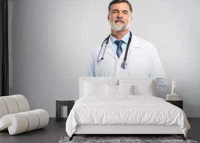 Cheerful mature doctor posing and smiling at camera, healthcare and medicine. Wall mural