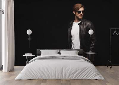 Fashion man, Handsome serious beauty male model portrait wear sunglasses and leather jacket, young guy over black background Wall mural