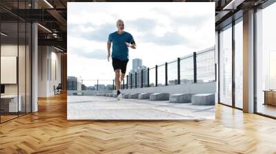 Fitness, workout, sport, lifestyle concept. Middle-aged man running in the city Wall mural