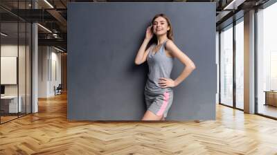 fitness woman. Young sporty Caucasian female model isolated on gray background. Wall mural