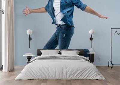 Full length portrait of a happy excited beardedman jumping and looking at camera isolated over grey background. Wall mural